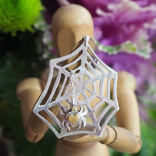 A beautiful unique hand cut recycled sterling silver web pendant with a handmade fine silver spider with a 24k gold body.