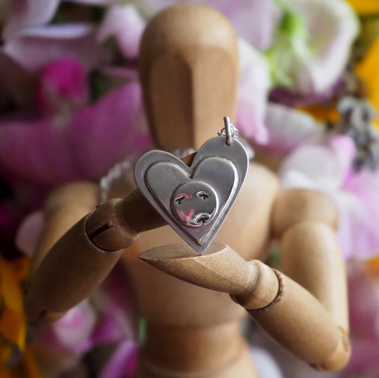 A stunning sterling silver heart pendant layered with another heart and a disc showing a flock of seagulls, hung on a sterling silver chain.