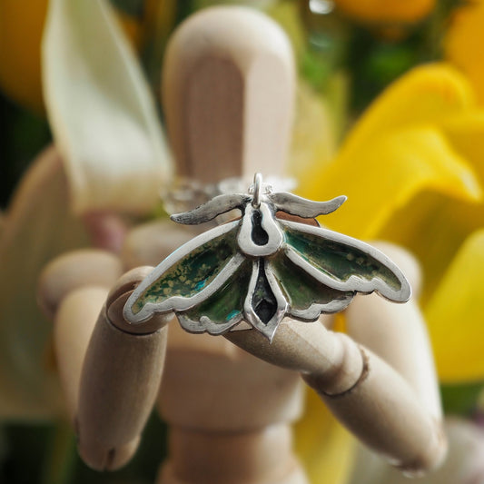 A beautiful moth pendant, handmade in fine silver and hand enamelled, hung on a sterling silver chain.