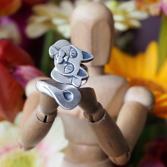 A unique handmade beautiful Maneki-neko style cat head and tail ring in fine silver on an adjustable sterling silver band.