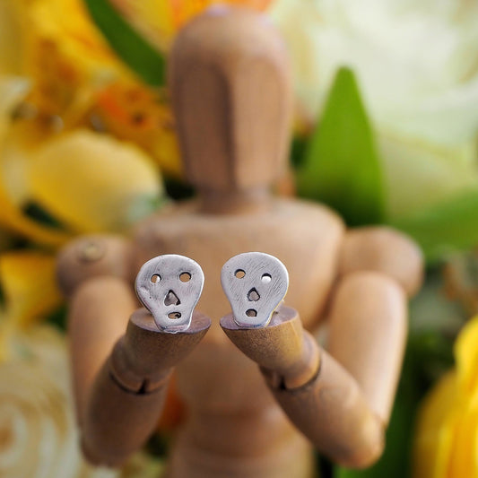 A tiny super simple little pair of fine silver skull stud earrings on sterling silver posts.