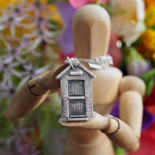 A super cute little eco friendly fine silver beach hut pendant hung on a sterling silver chain.