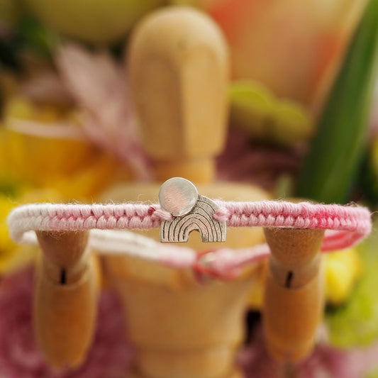 A beautiful small sized soft pinks leather and cotton friendship bracelet with a simple tiny fine silver moon and rainbow