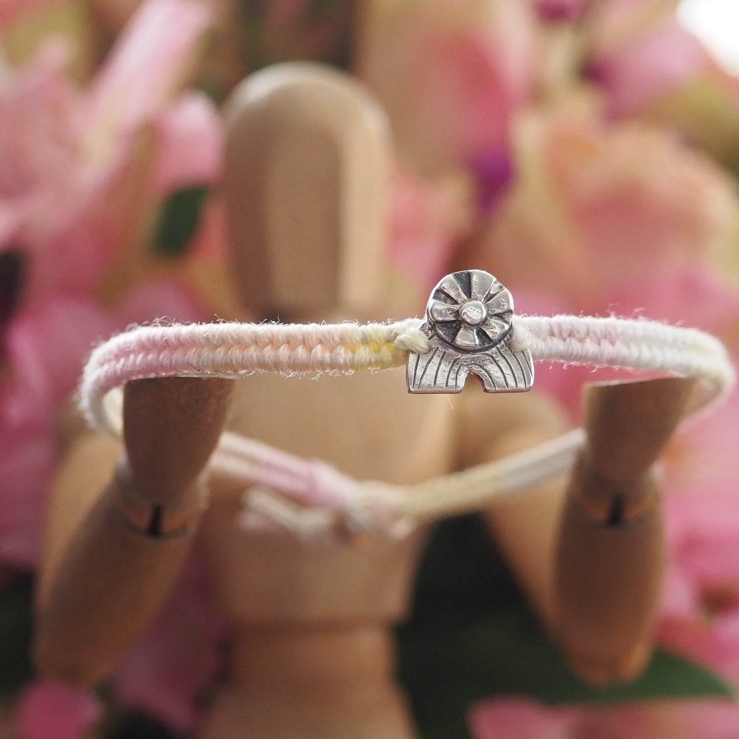 A beautiful small sized peachy pink fade leather, sterling silver and cotton friendship bracelet with a tiny fine silver sun and rainbow