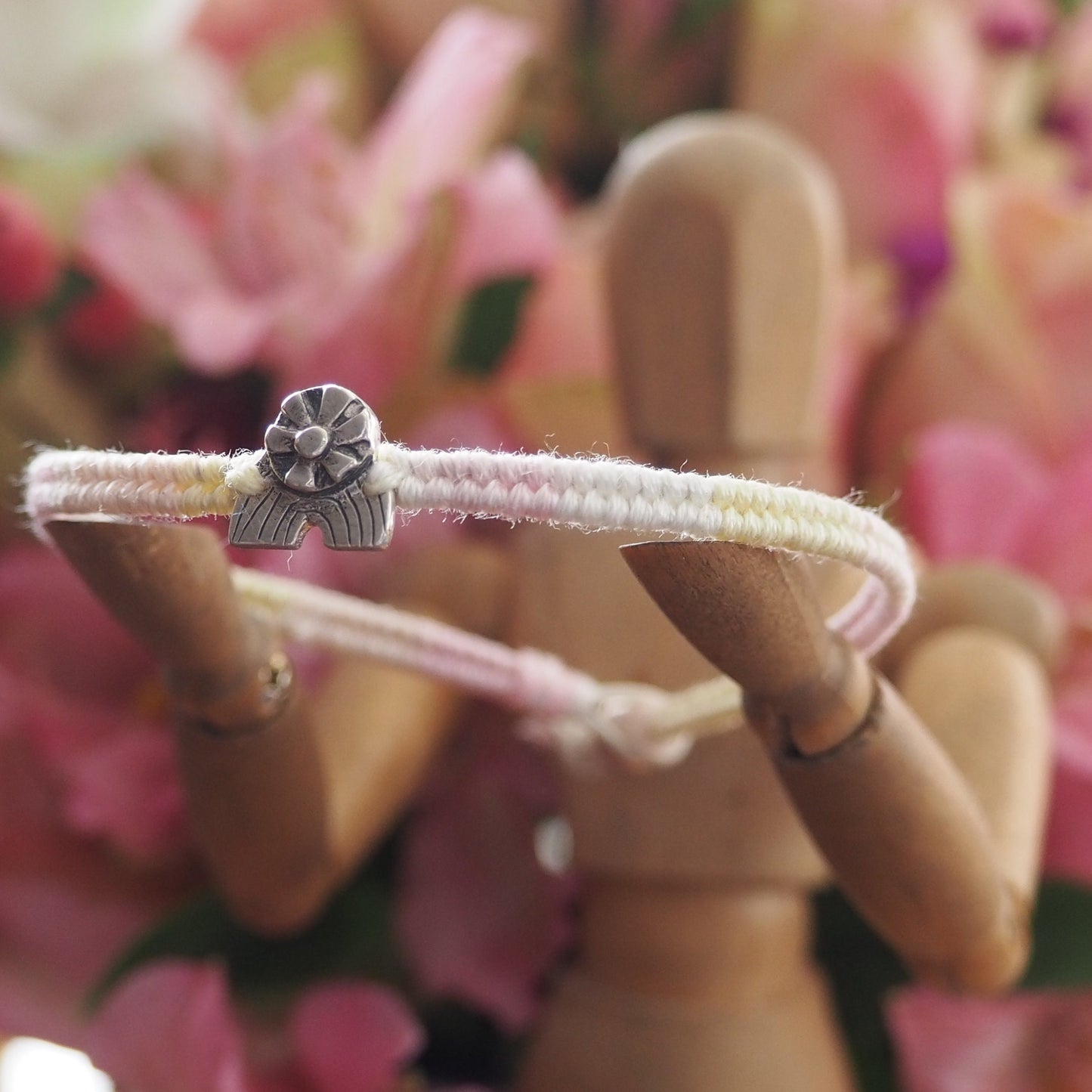 A beautiful small sized peachy pink fade leather, sterling silver and cotton friendship bracelet with a tiny fine silver sun and rainbow