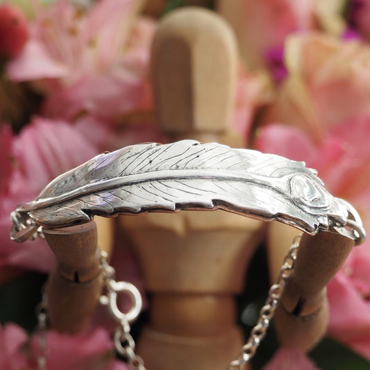 A stunning handmade fine silver peacock feather backed with hand cut copper on a sterling silver chain bracelet.