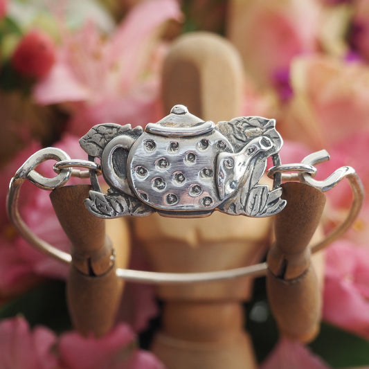 An adorable spotty tea pot and tea roses in handmade in fine silver on a hand beaten sterling silver bangle.