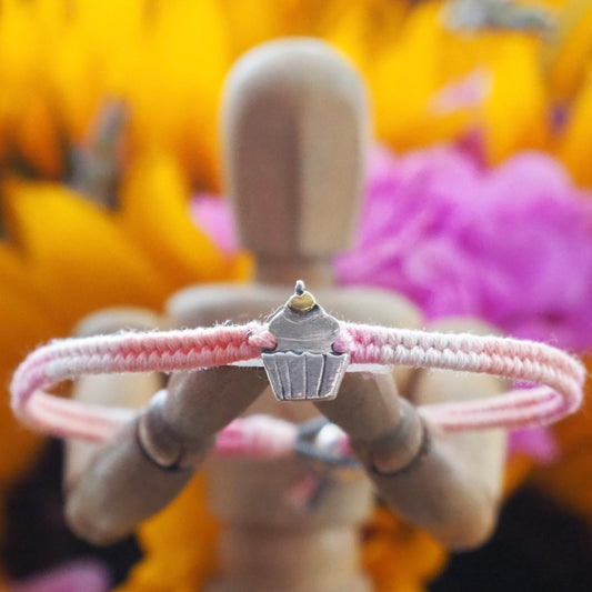 A beautiful pinky leather, cotton and sterling silver friendship bracelet with a lovely fine silver cupcake topped with a 24k gold cherry.