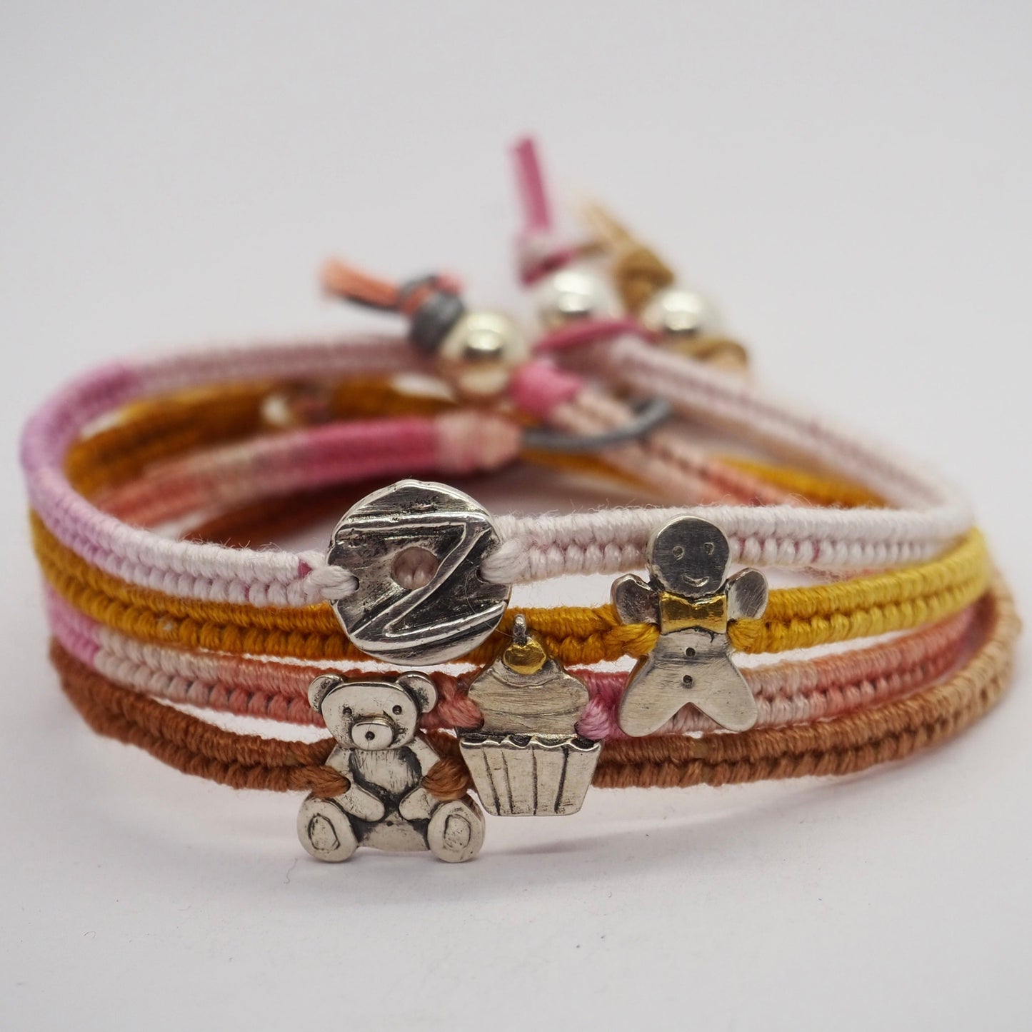 A beautiful pinky leather, cotton and sterling silver friendship bracelet with a lovely fine silver cupcake topped with a 24k gold cherry.