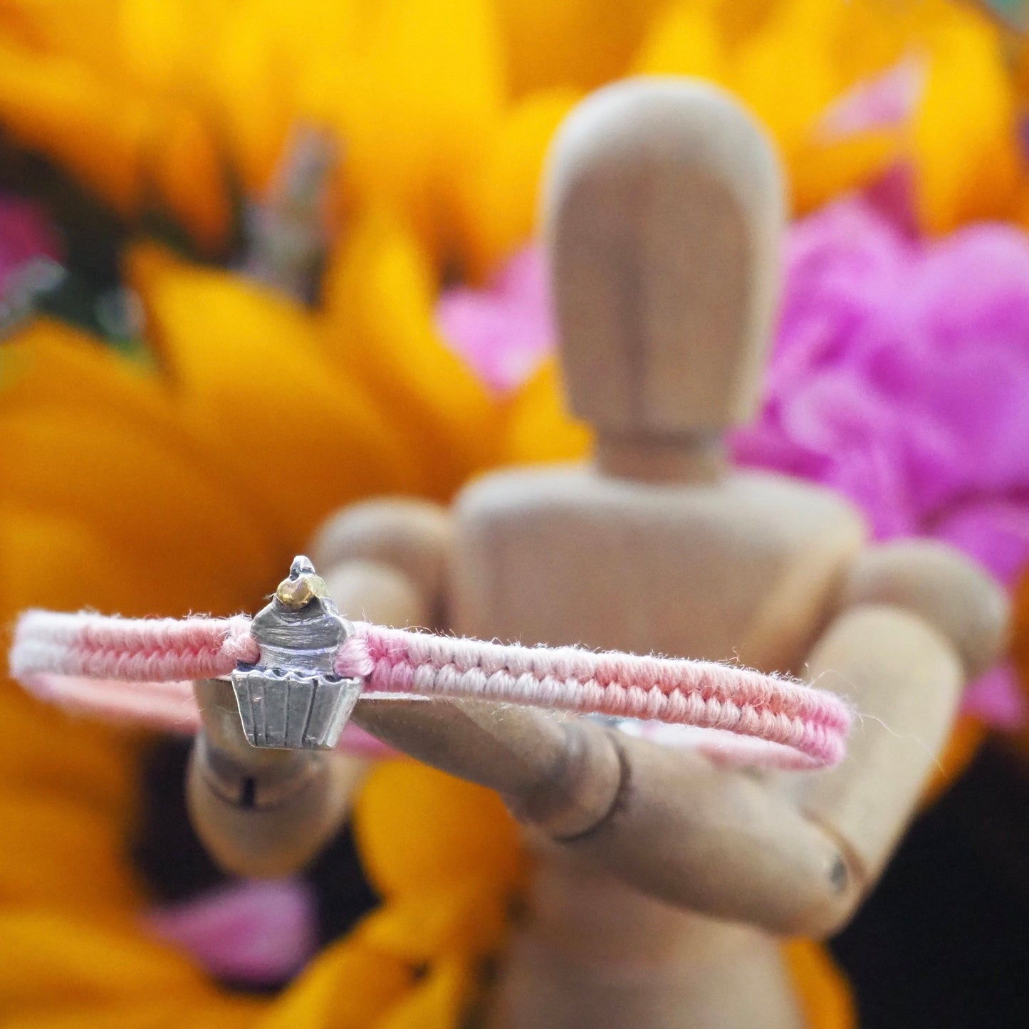 A beautiful pinky leather, cotton and sterling silver friendship bracelet with a lovely fine silver cupcake topped with a 24k gold cherry.