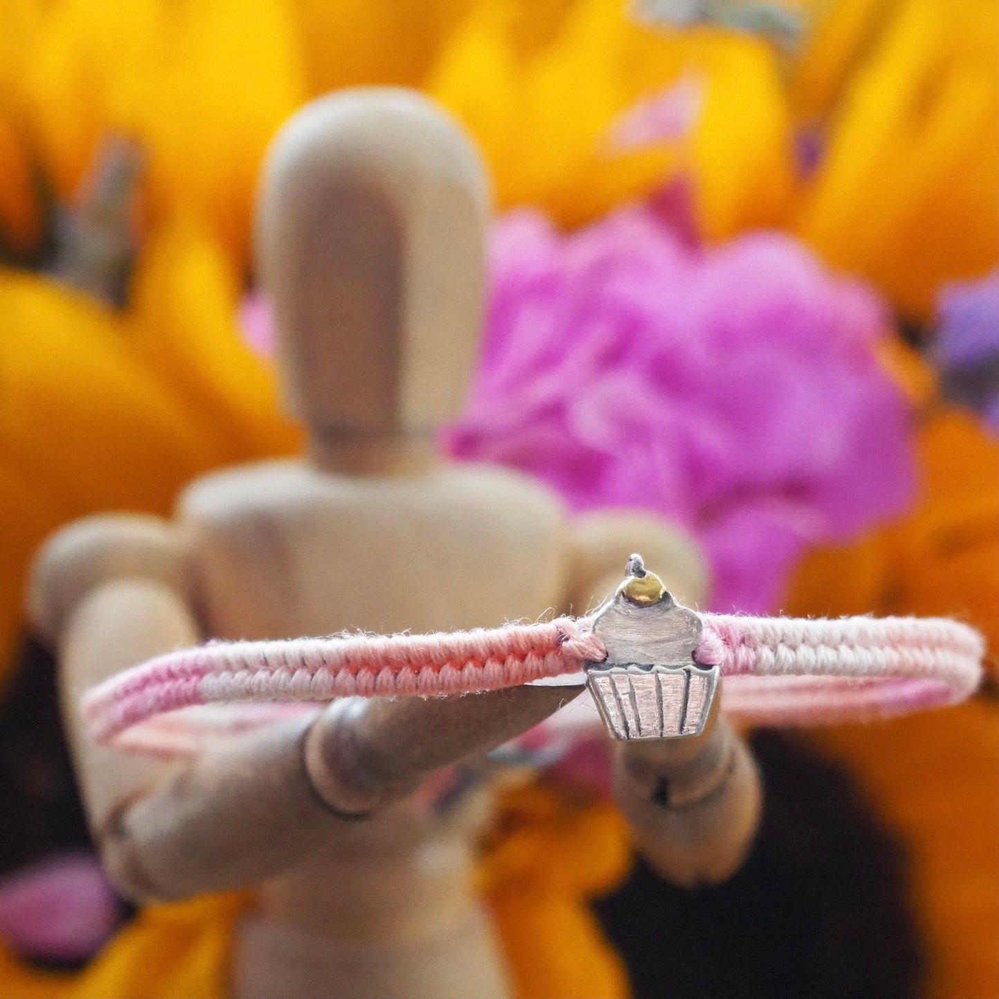 A beautiful pinky leather, cotton and sterling silver friendship bracelet with a lovely fine silver cupcake topped with a 24k gold cherry.