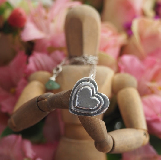 A gorgeous tiny handmade sterling silver layered heart pendant on a sterling silver chain finished off with a gemstone clip.