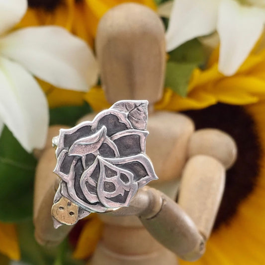 A gorgeous fine silver hand made tattoo style rose ring set on a pretty hand twisted sterling silver band.