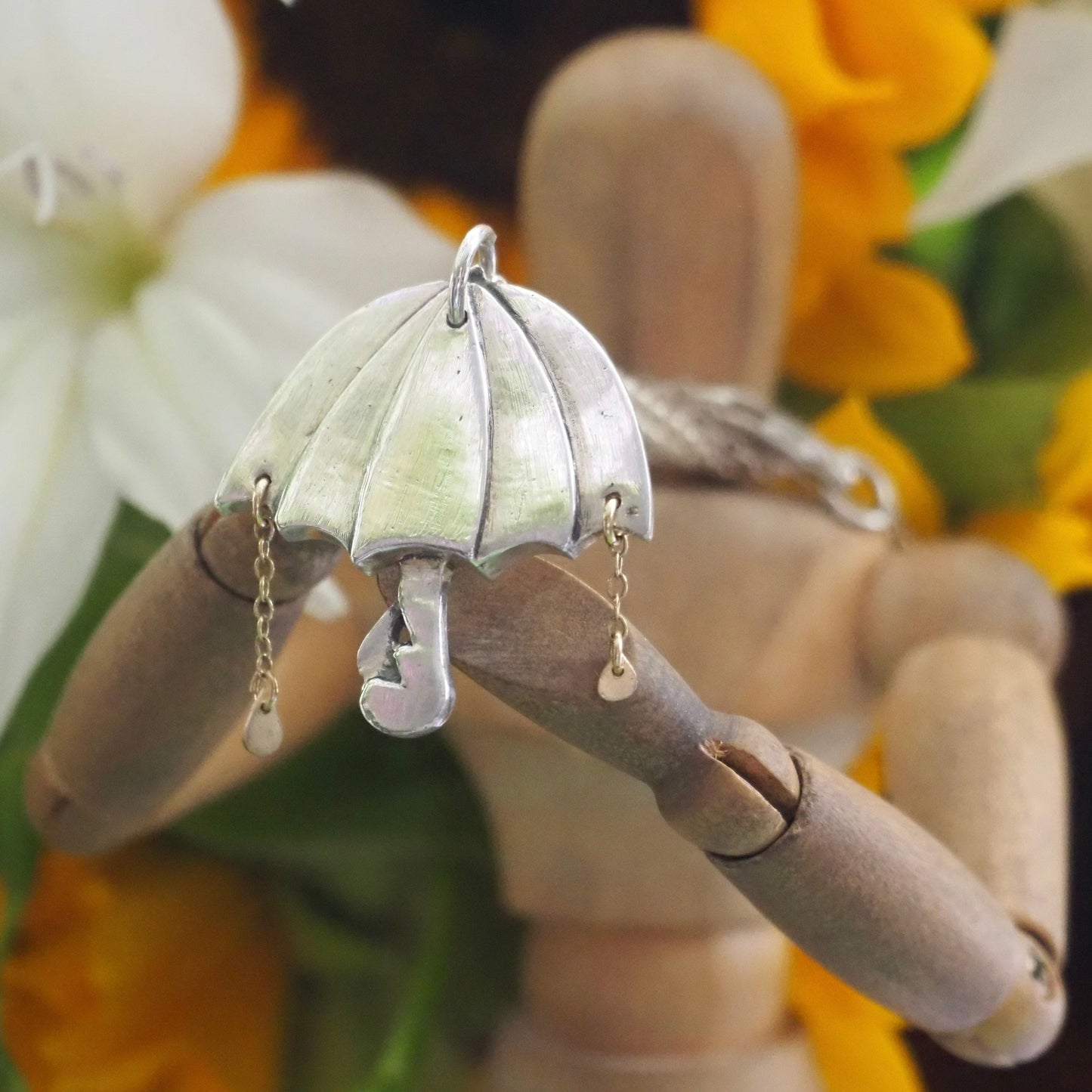 A beautiful unique fine silver flamingo umbrella necklace with tiny gold rain drops.