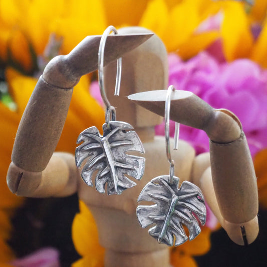 A beautiful pair of handmade eco friendly fine silver monstera leaf earrings on sterling silver wires.