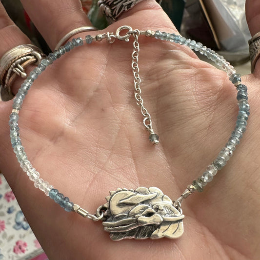 A gorgeous handmade fine silver cold water sea swimmer charm strung on a bracelet of tiny aquamarine beads and sterling silver.