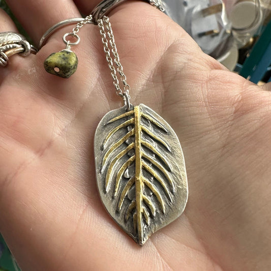 A gorgeous maranta leaf handmade in eco friendly fine silver highlighted with 24k gold on a sterling silver necklace.