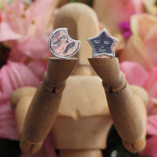 A gorgeous pair of happy smiling fine silver star and moon stud earrings on sterling silver posts.