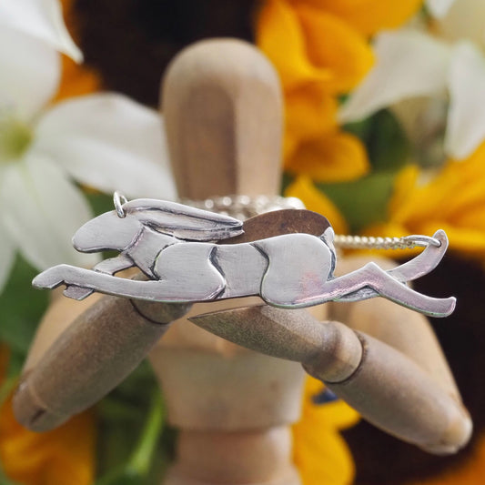 A wonderfully simple leaping hare necklace hand made in eco friendly fine silver hung on a sterling silver chain.