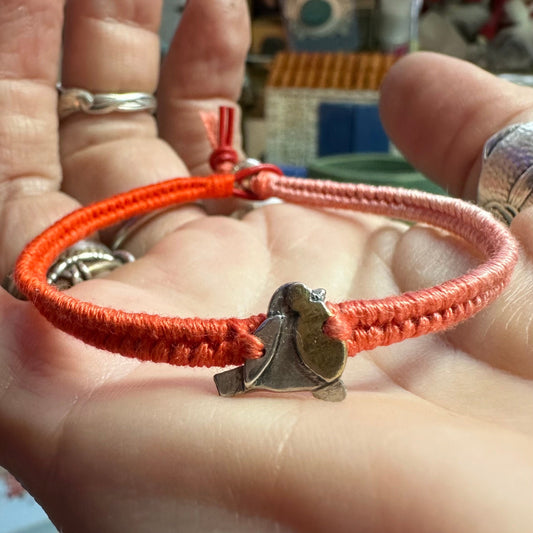 A cute handmade fine silver robin with gold chest on a vivid red leather, cotton and sterling silver woven friendship bracelet…