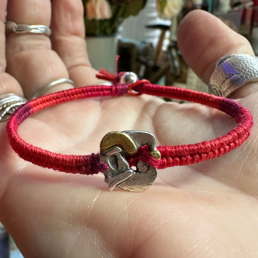 An adorable handmade fine silver Santa with gold trim on a vivid red leather, cotton and sterling silver woven friendship bracelet…