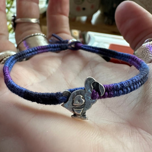 A lovely handmade fine silver dodo, on blue/purple leather and cotton friendship bracelet finished with a sterling silver bead.
