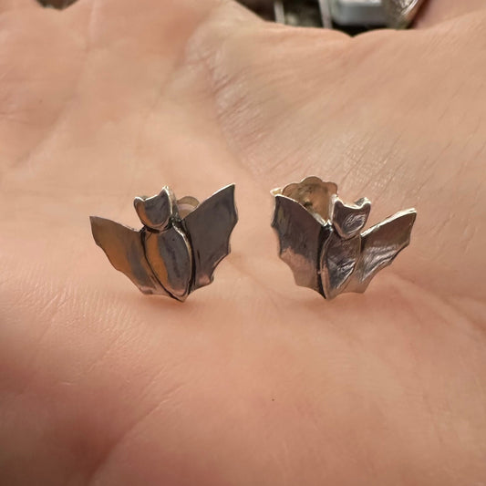 A pair of tiny little gothic bat stud earrings hand made in fine silver on sterling silver posts.