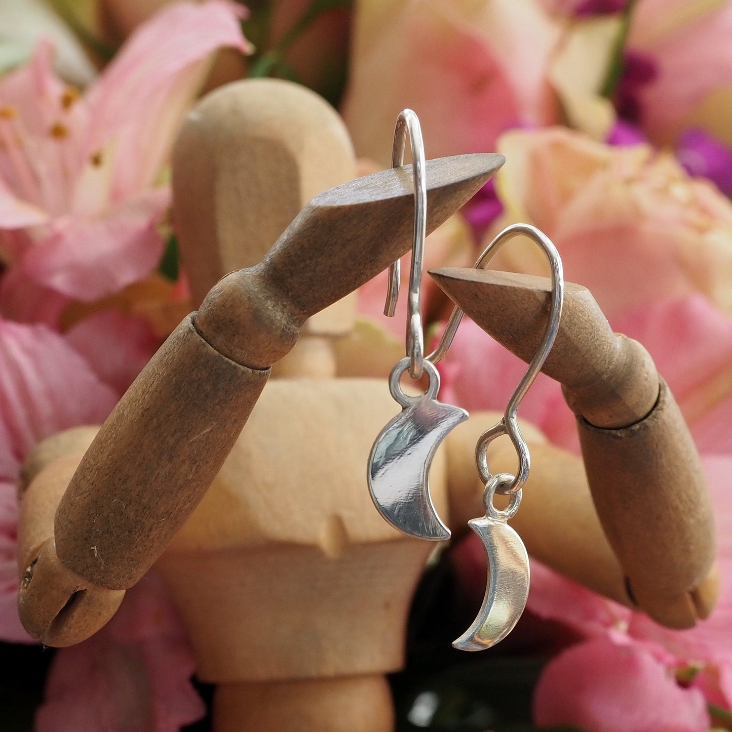 A simple handmade pair of eco friendly fine silver little crescent moon earrings on long sterling silver wires