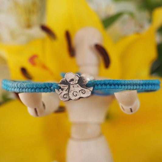 A cute tiny handmade fine silver octopus on a beautiful turquoise blue leather, sterling silver and cotton friendship bracelet.