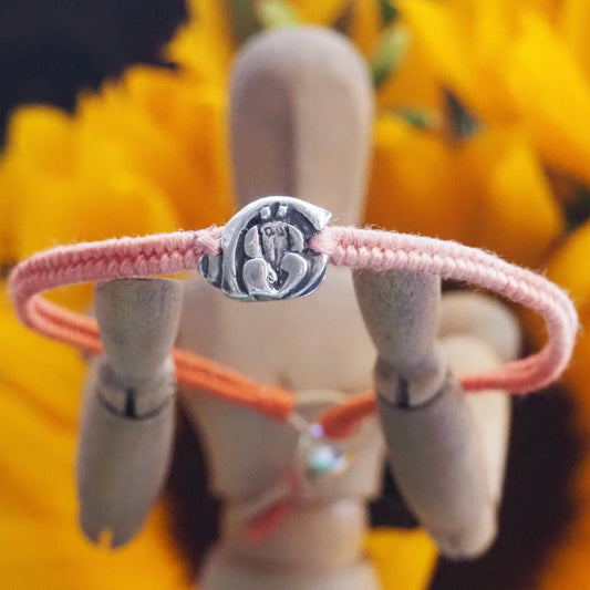 A beautiful tiny handmade fine silver hermit crab on a peachy pinks leather and cotton woven charm bracelet…