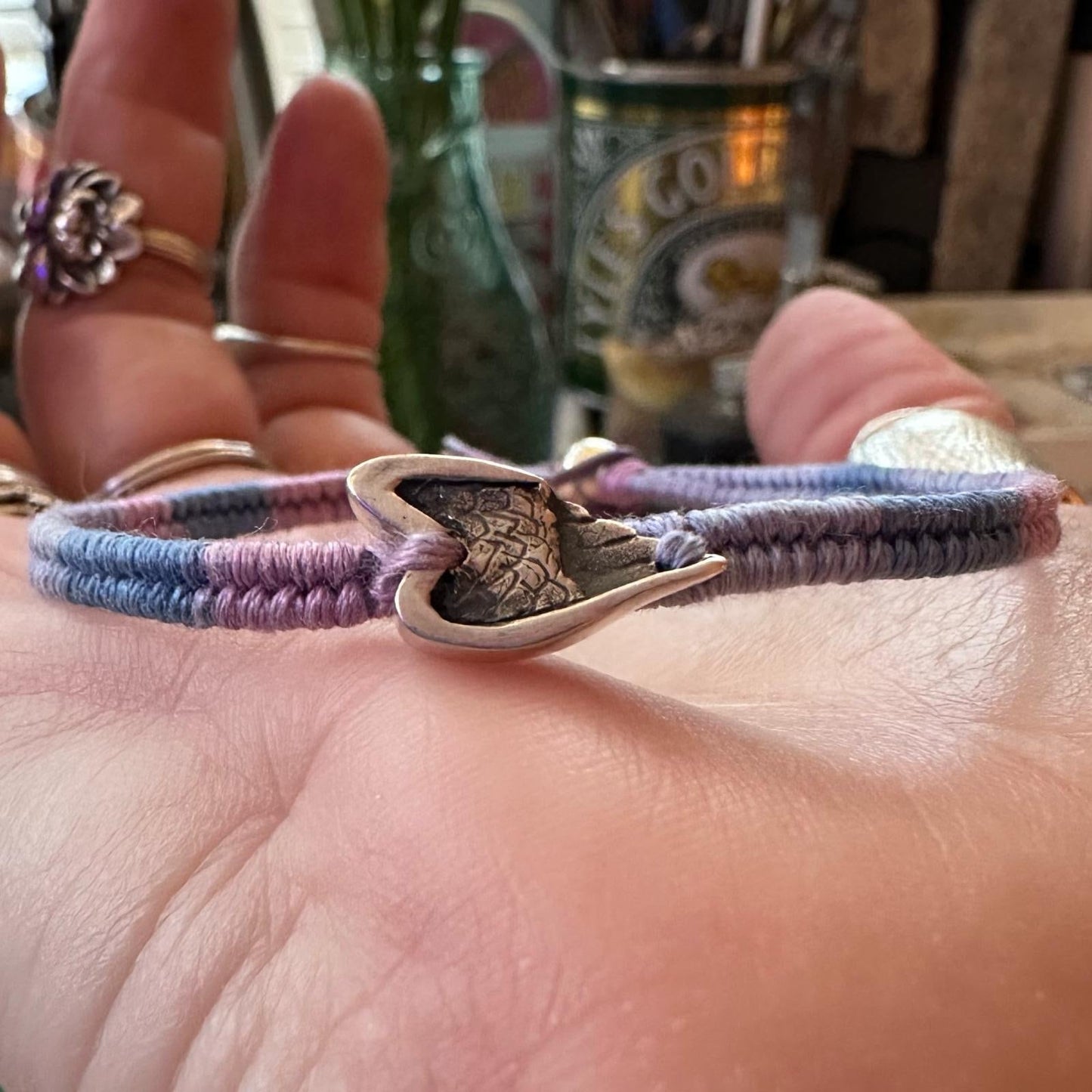 A beautiful little fine silver angel wing on a beautiful pinky purple leather, cotton and sterling silver woven charm bracelet.