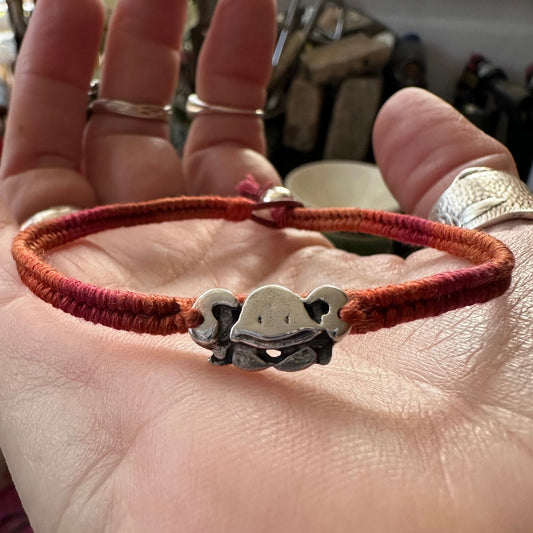 A cute handmade fine silver crab on a vivid red and orange leather, cotton and sterling silver woven friendship bracelet…