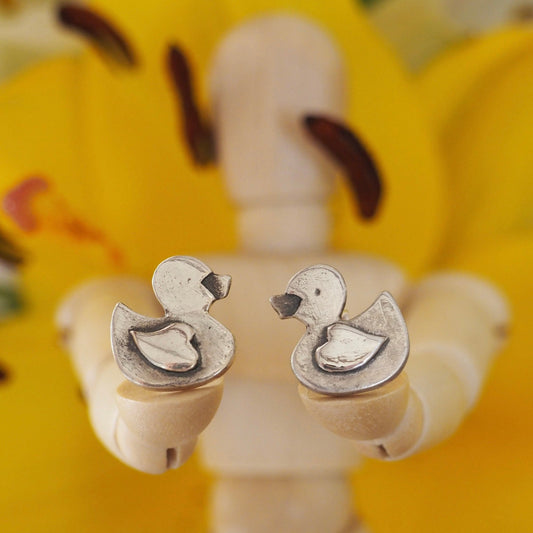 A pair of adorable tiny rubber duck stud earrings handmade in fine silver set on sterling silver posts.