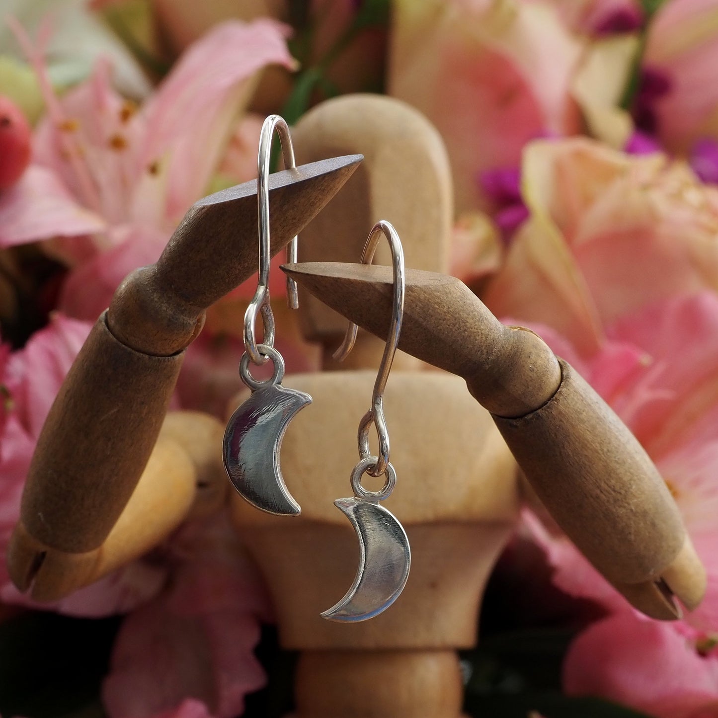 A simple handmade pair of eco friendly fine silver little crescent moon earrings on long sterling silver wires