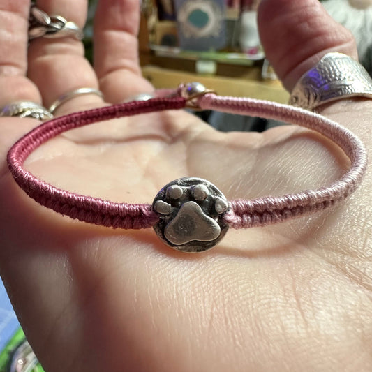 An adorable hand made fine silver paw print on a beautiful soft pink leather, sterling silver and cotton friendship bracelet.