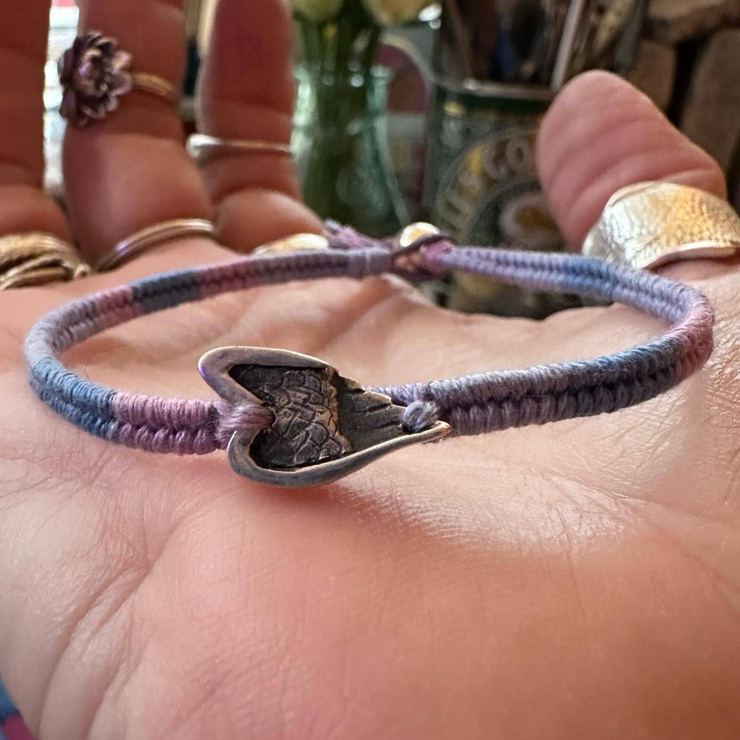 A beautiful little fine silver angel wing on a beautiful pinky purple leather, cotton and sterling silver woven charm bracelet.