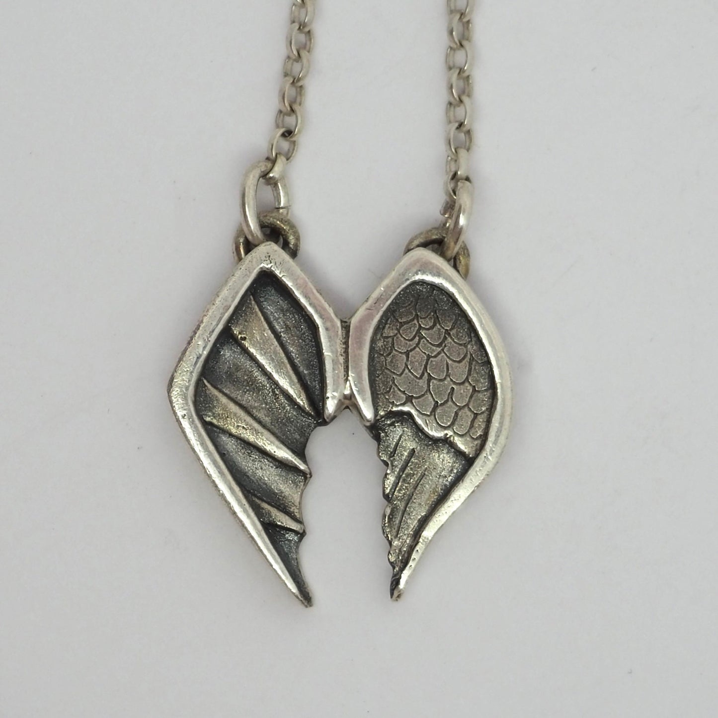 A pair of gorgeous fine silver angel and devil wings pendant on a sterling silver chain.