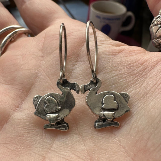 A gorgeous pair of handmade fine silver dodo earrings hung on sterling silver wires.