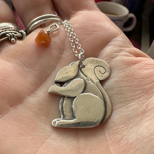 A beautiful solid fine silver squirrel pendant on a sterling silver chain with a gem attached to the end.