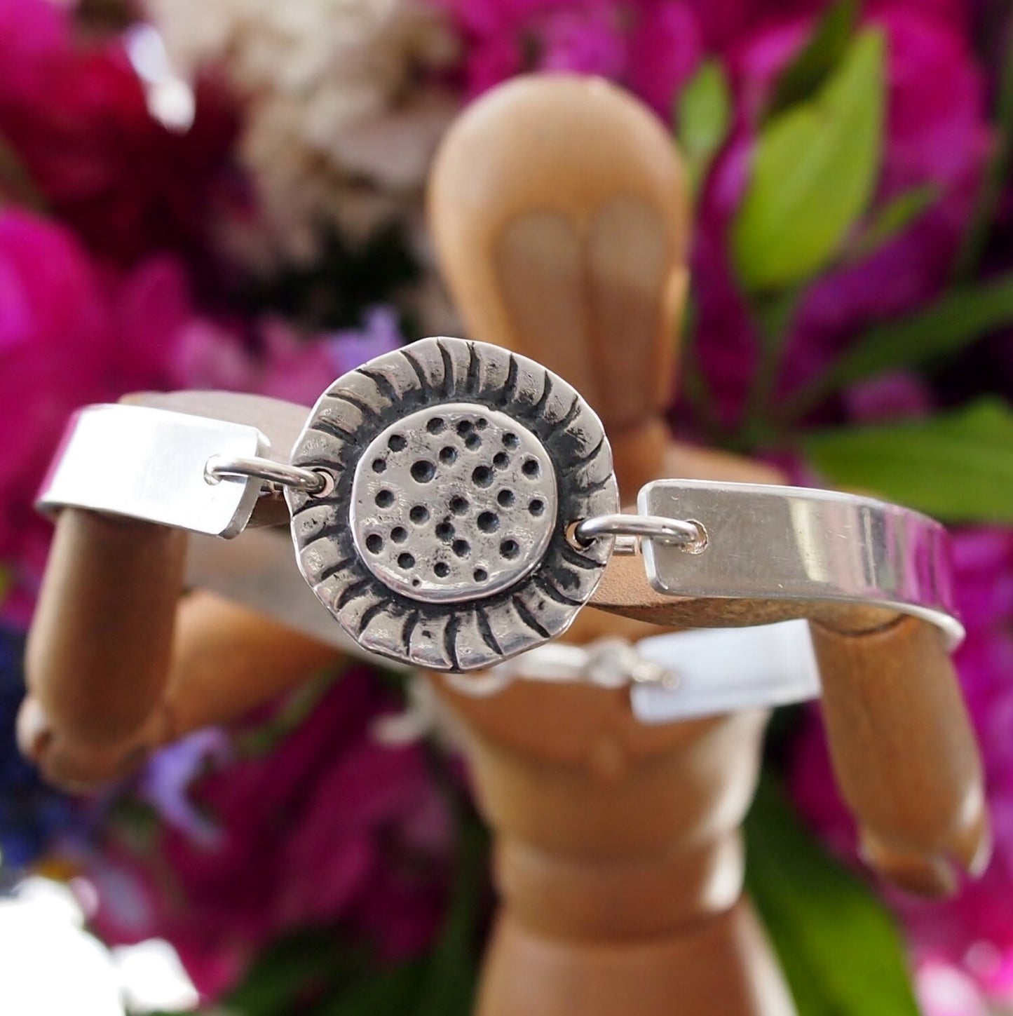 A simple fine silver sunflower set on a sterling silver bangle.