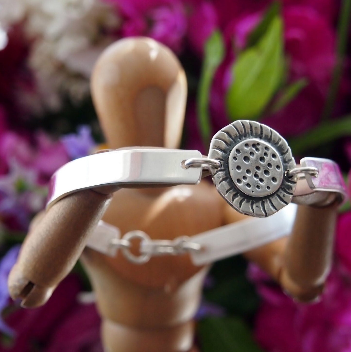 A simple fine silver sunflower set on a sterling silver bangle.