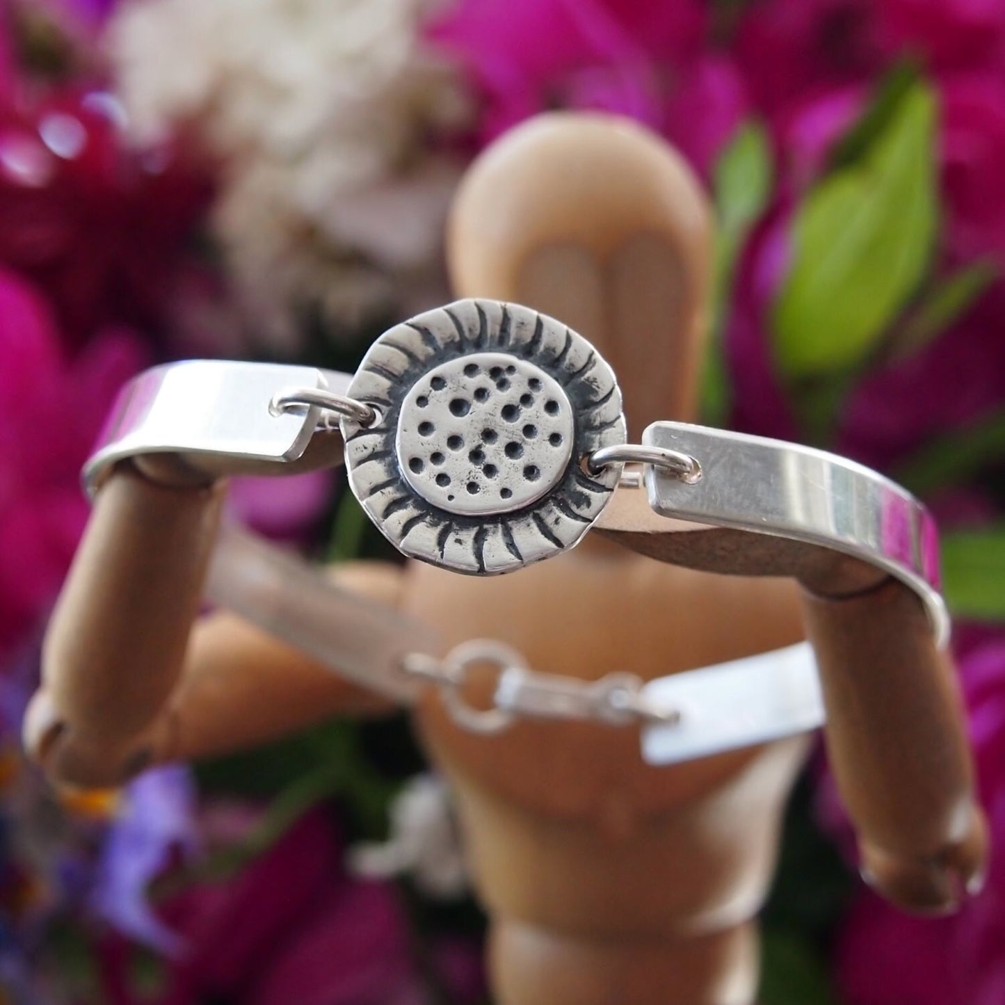 A simple fine silver sunflower set on a sterling silver bangle.