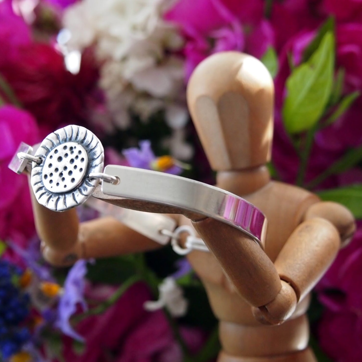 A simple fine silver sunflower set on a sterling silver bangle.